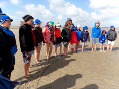 a group of people standing in the sand