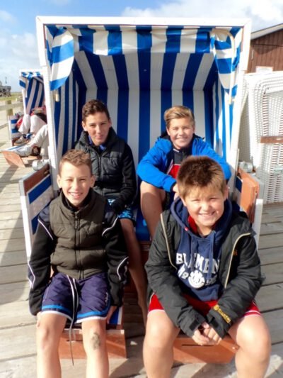 a group of boys sitting in a beach chair