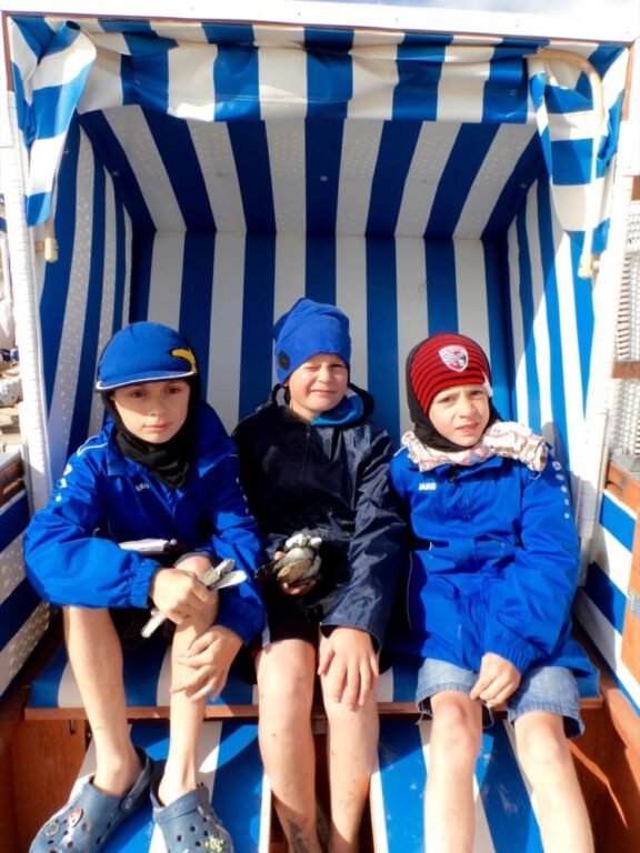 a group of children sitting in a beach chair