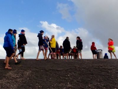 a group of people standing on a hill with Cadillac Ranch in the background