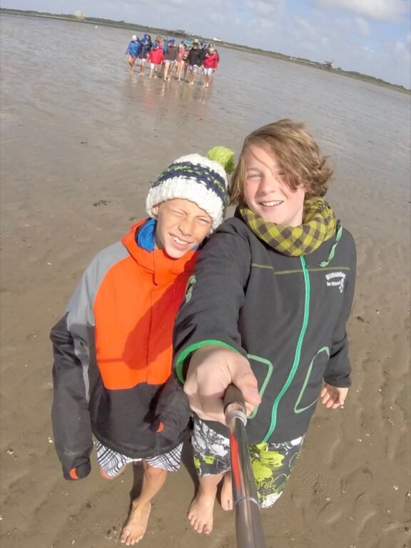 a selfie of two boys on a beach