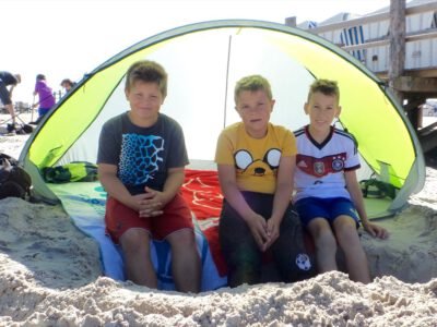 a group of boys sitting under a tent