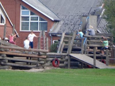 a group of kids playing on a wooden structure