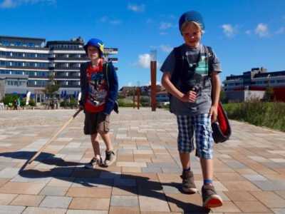 two boys walking on a brick walkway