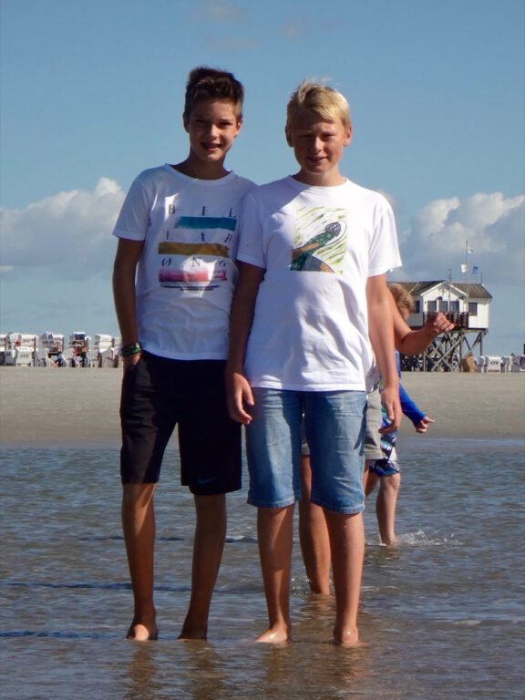 two boys standing in the water