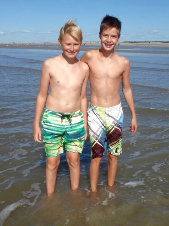 two boys standing in the water