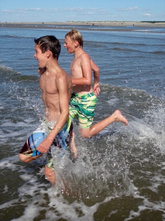 two boys running in the water