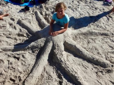 a girl sitting in sand