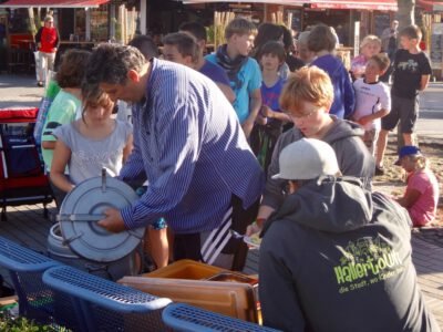 a group of people standing around a man holding plates