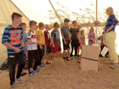 a group of people standing in sand