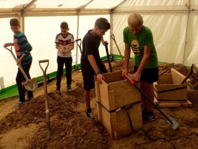 a group of kids digging in sand
