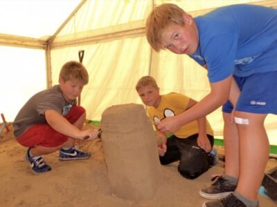 a group of boys building a sand castle