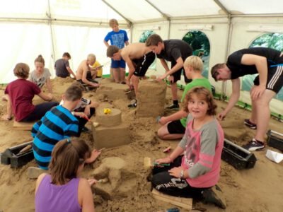 a group of kids building sand in a tent