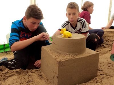 a group of boys sitting in sand
