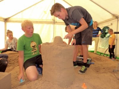 a group of boys building a sand castle
