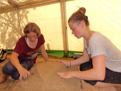 a couple of girls playing with sand