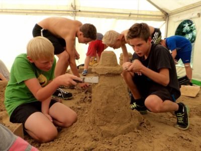 a group of boys building a sandcastle