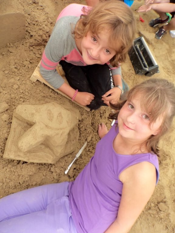 two children sitting in sand