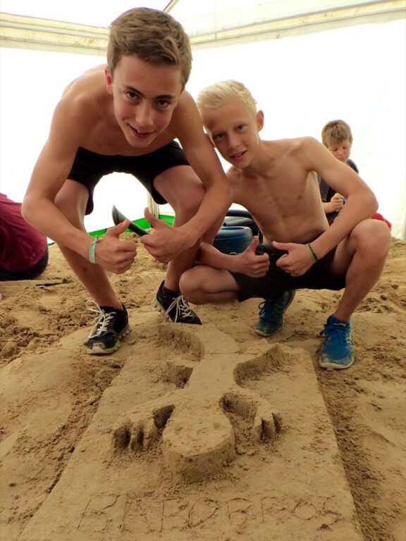 two boys posing for a picture in the sand