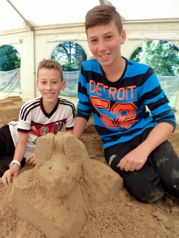 two boys posing with sand