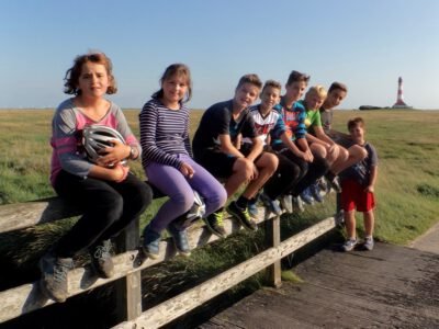a group of children sitting on a fence