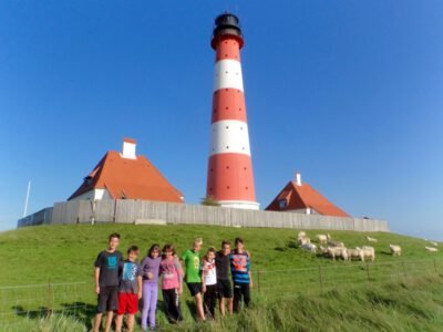 a group of people standing in front of a lighthouse