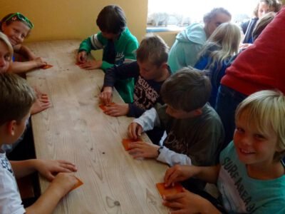 a group of kids sitting around a table playing cards