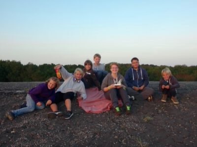 a group of people sitting on a blanket