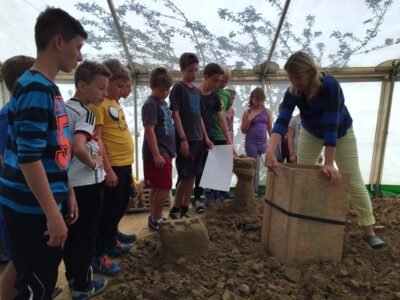 a group of people standing in a room with a woman standing in sand