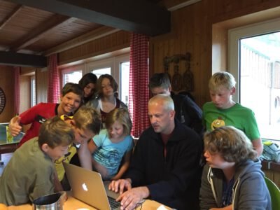 a group of people around a laptop