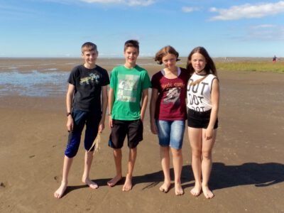 a group of kids standing on a beach