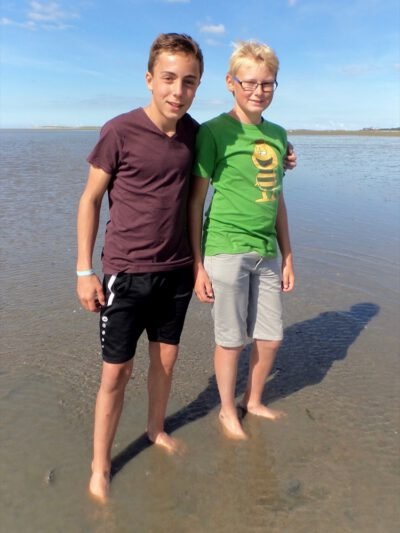 two boys standing on a beach