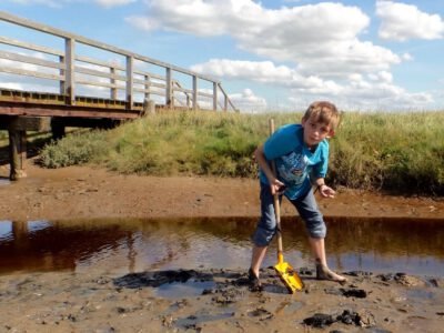 a boy playing in a puddle