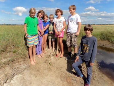 a group of children standing in a field