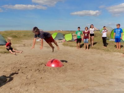 a group of people playing with a red ball