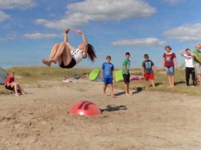 a woman jumping in the air with other people watching
