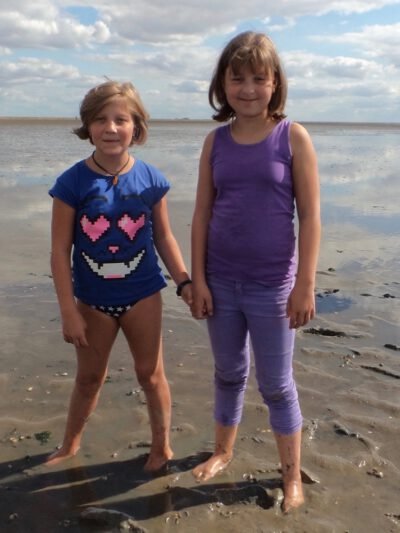 two girls standing on a beach
