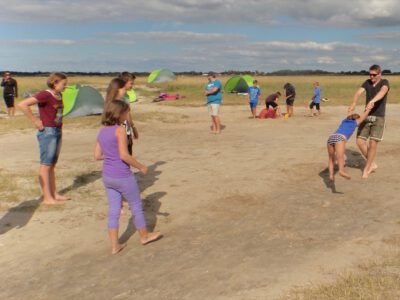a group of people outside on a dirt field