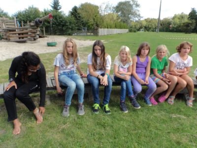 a group of girls sitting on a bench