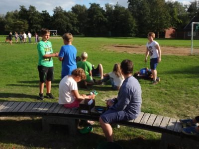 a group of people sitting on a bench in a field