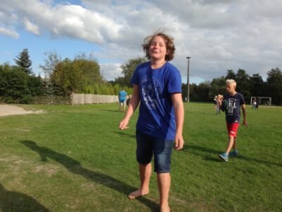 a boy standing on grass