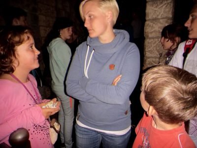 a woman standing with her arms crossed and a group of children