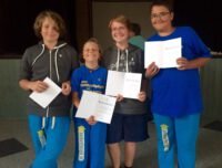 a group of kids holding papers