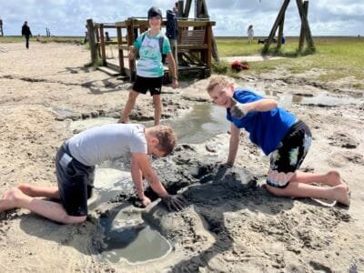 Kinder spielen im Sand am Strand.