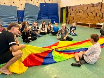 Kinder spielen mit einem Fallschirm.