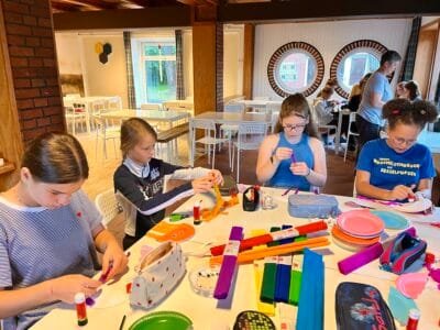 Kinder basteln mit verschiedenen Materialien.