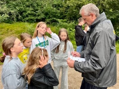Gruppengespräch im Freien, Erwachsene und Kinder.