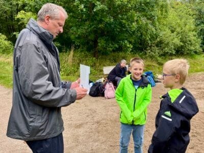 Mann spricht mit zwei Kindern.