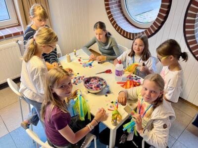 Kinder basteln mit bunten Materialien.