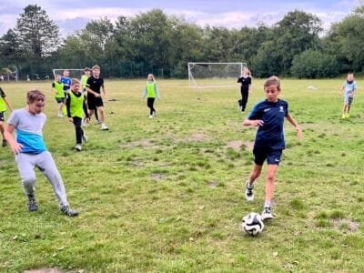 Kinder spielen Fußball auf dem Feld.